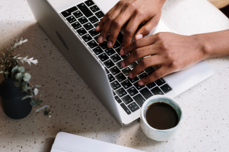 Mains pianotant un clavier d'ordinateur